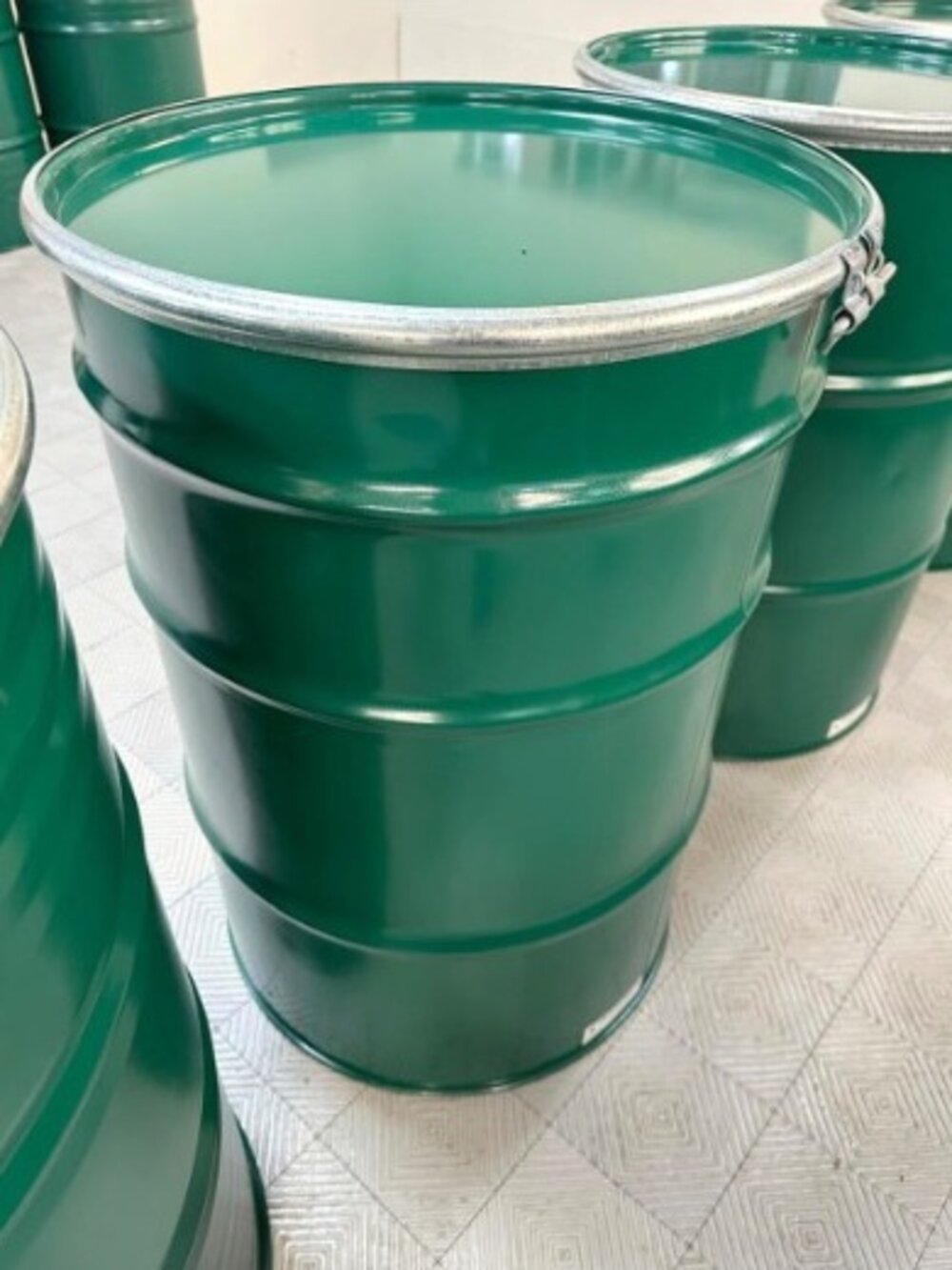 Tambores verde oscuro apilados en planta